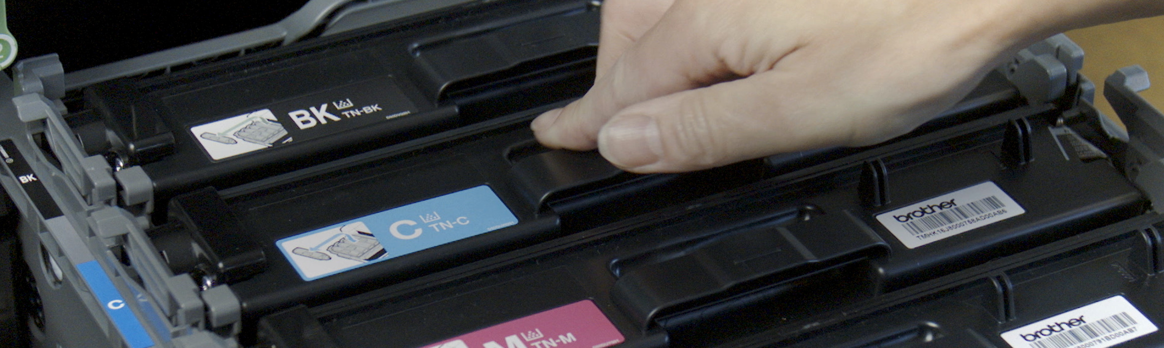 Printer open with person putting in toner cartridge
