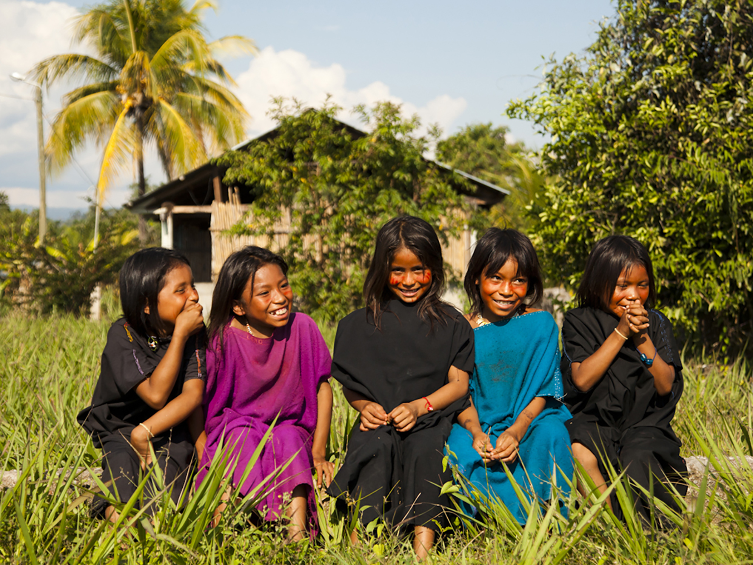 Kids in colorful clothing sitting in grass