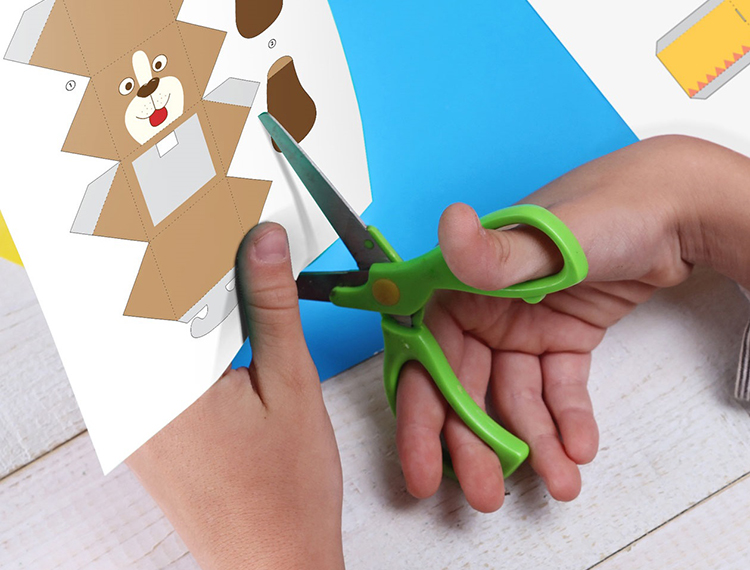 Person cutting out a picture of a dog from creative centre 