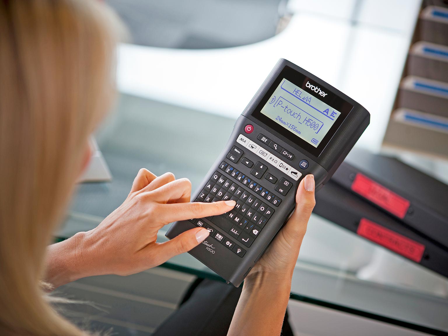 Dame med brother P-touch H500 merkemaskin