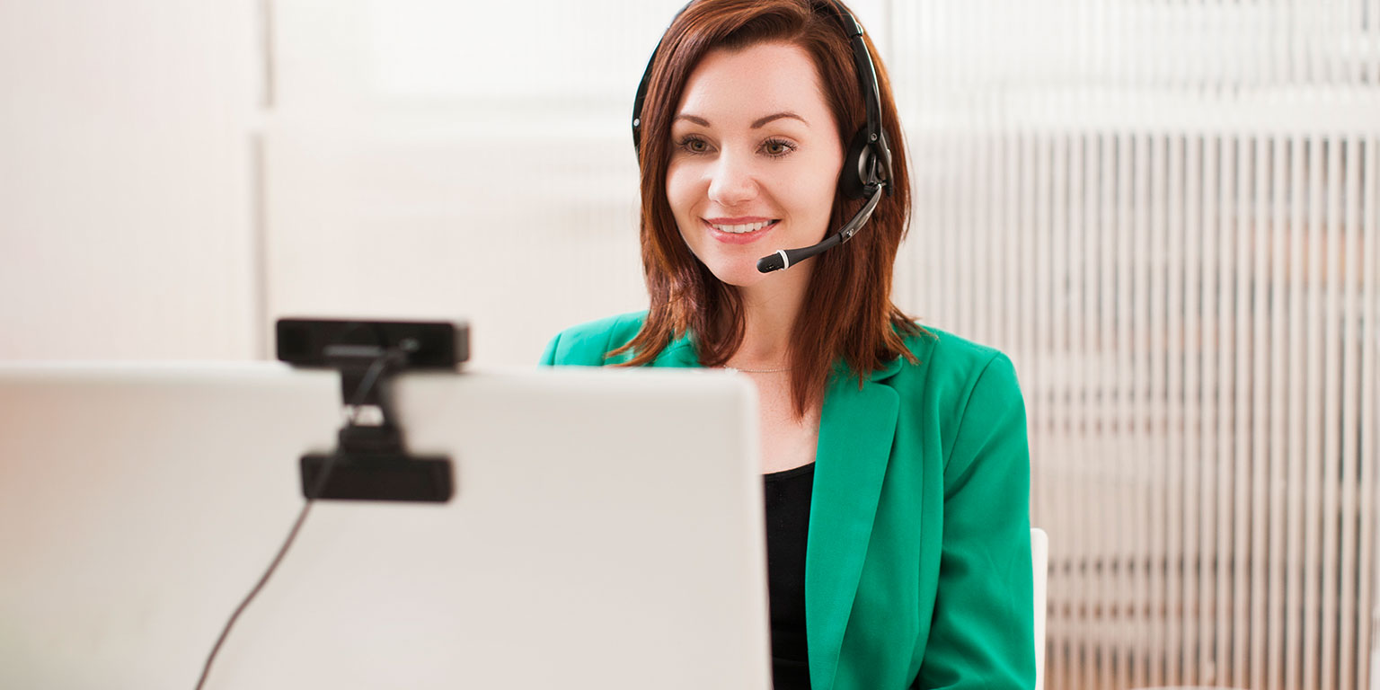 Woman in green jacket talking on video call