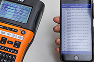 Brother iLink&Label-appen, der er åben på en smartphone og en Brother PT-E550WNIVP