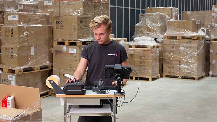 Mann skriver ut etiketter på bedriften Jollyroom
