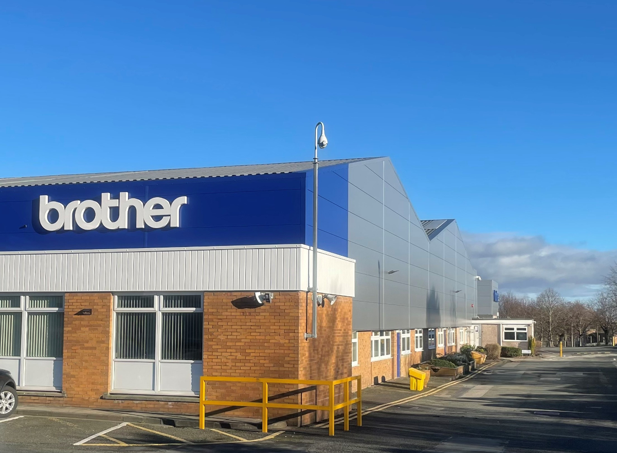 Oversiktsbilde av bygget til Brother Industries i England,  med Brother logo på veggen