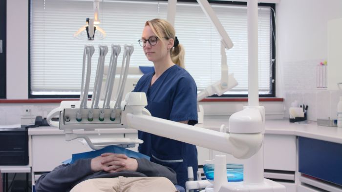 En tanntekniker sammen med en pasient