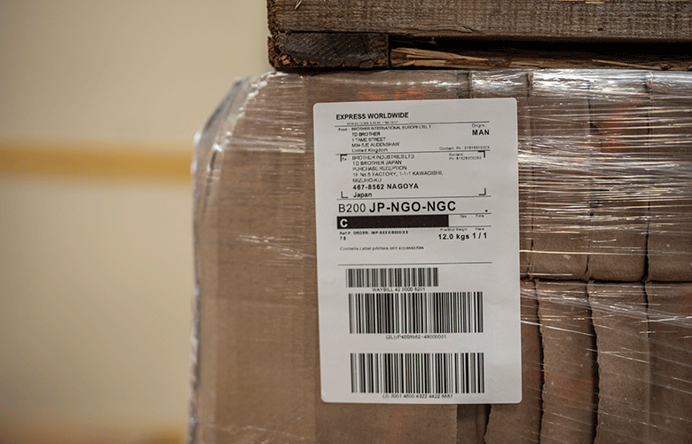 Close up of white shipping label on wrapped brown box