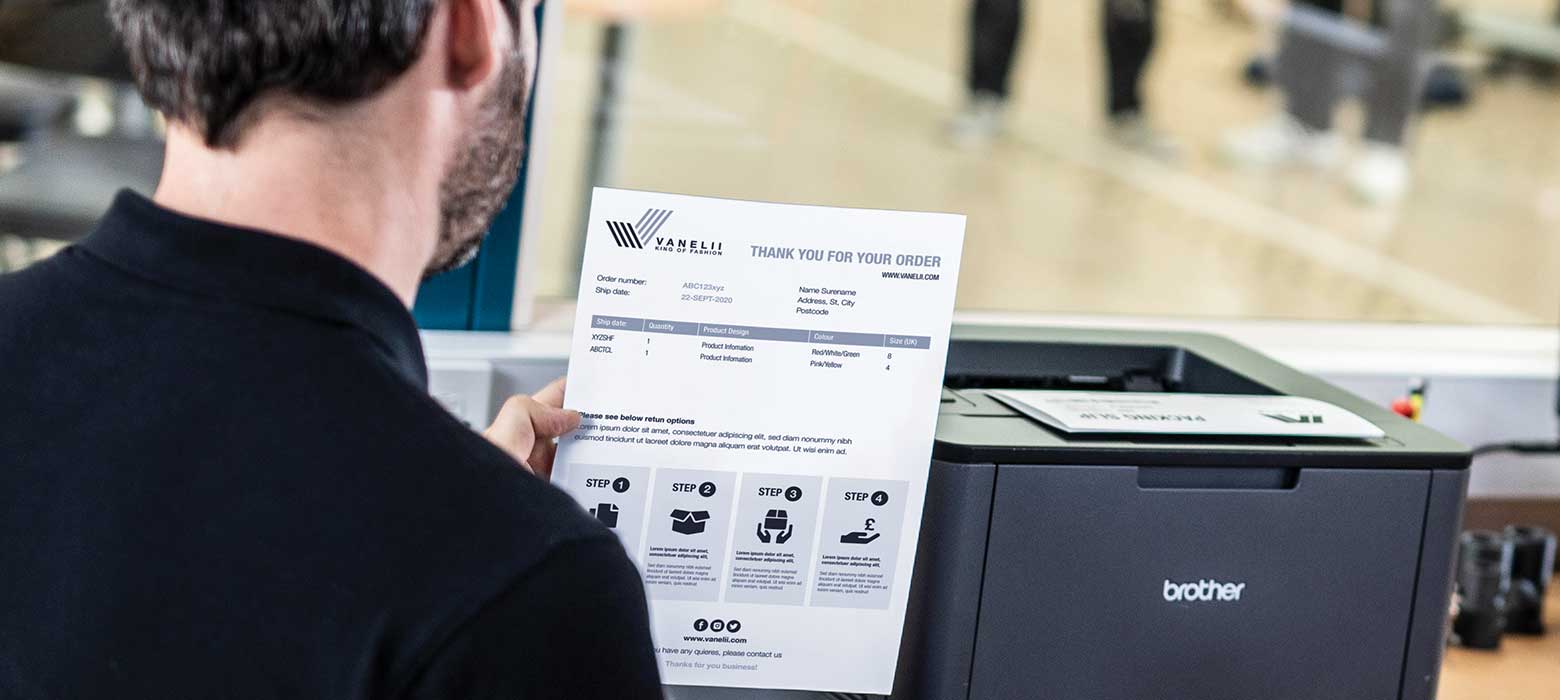 Man holding returns note, printer, wndow  in fulfilment centre