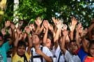 Skolebarn i Peru holder hendene i været