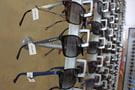 Briller med prisskilte, der hænger på væggen i en optikerbutik 