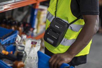 Arbeidstaker i en butikk med en RJ-etikett- og kvitteringsskriver over skulderen