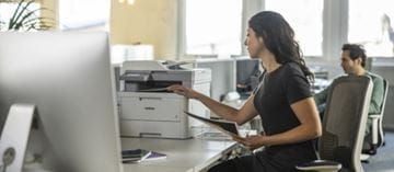 Nainen tekee töitä tulostimen lähettyvillä