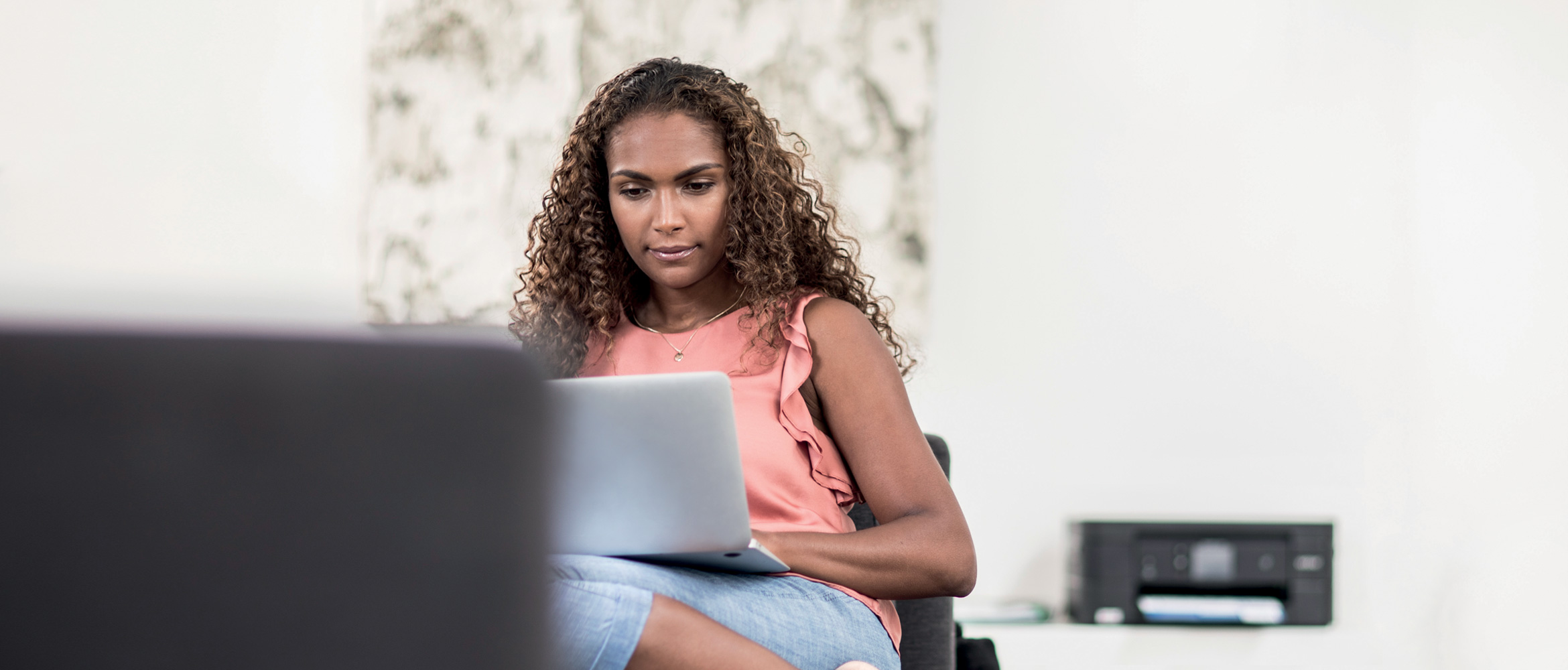 Mulher com cabelo rizadd sentado com laptop