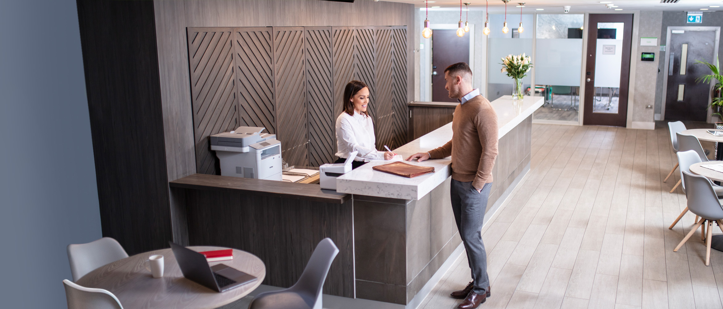 Store staff member talking with customer in hotel environment