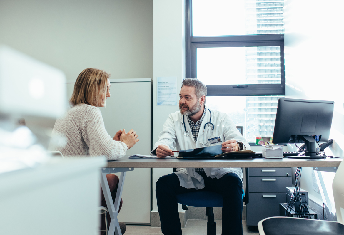Doctor and patient chatting in doctors surgery