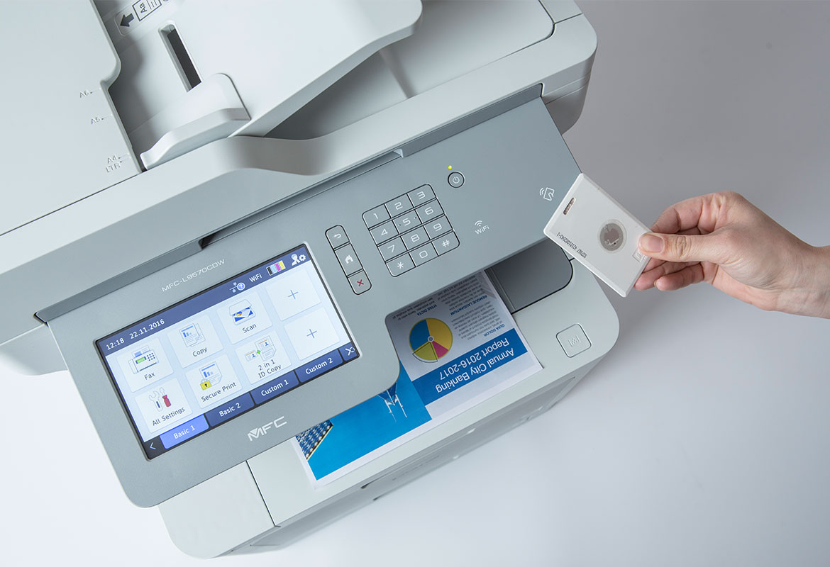 Person's hand holding card against Brother multifunction printer with large screen