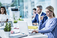 4 people in an office, with colour laser machine in the background