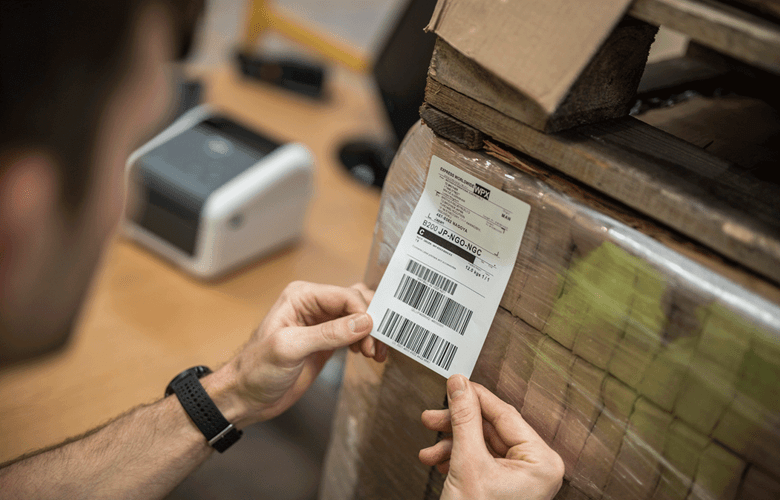 Man labelling boxes with delivery label