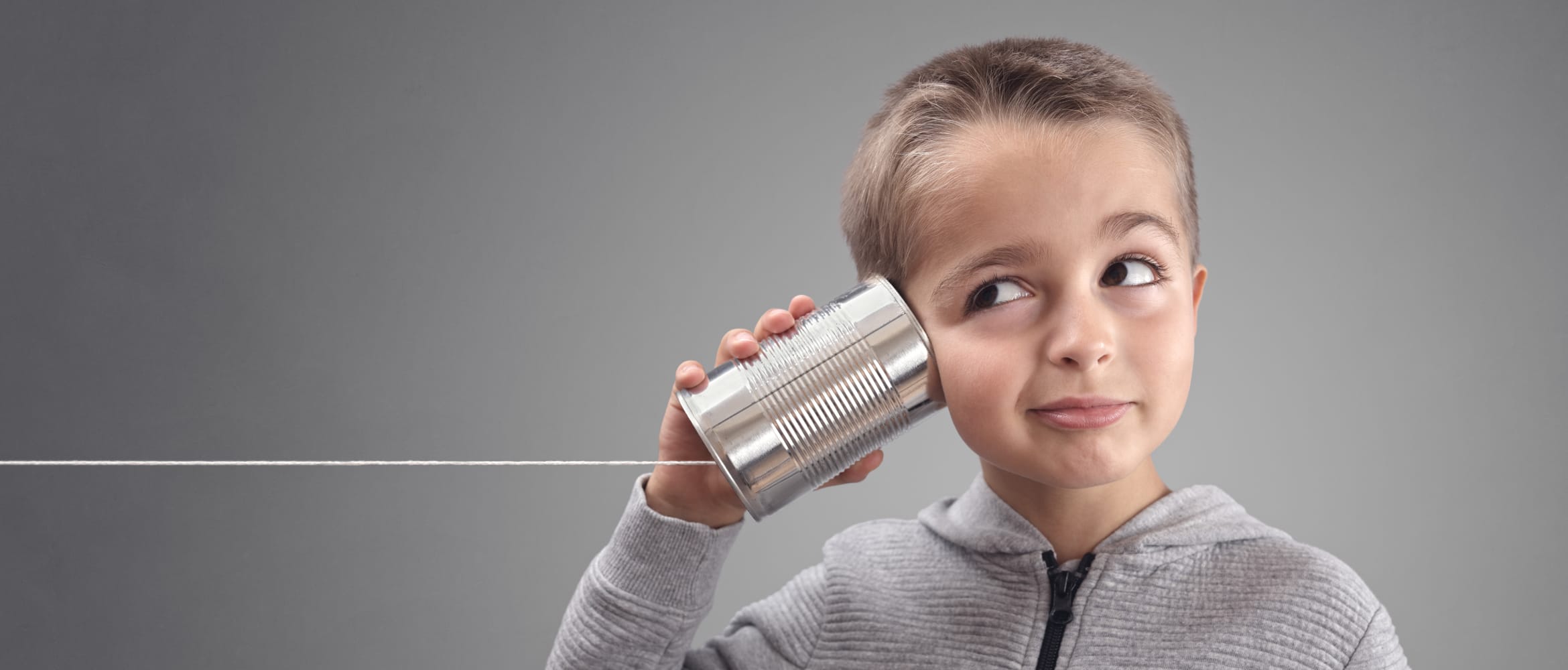 Young boy with can and string to his ear, highlighting the principles of remote working