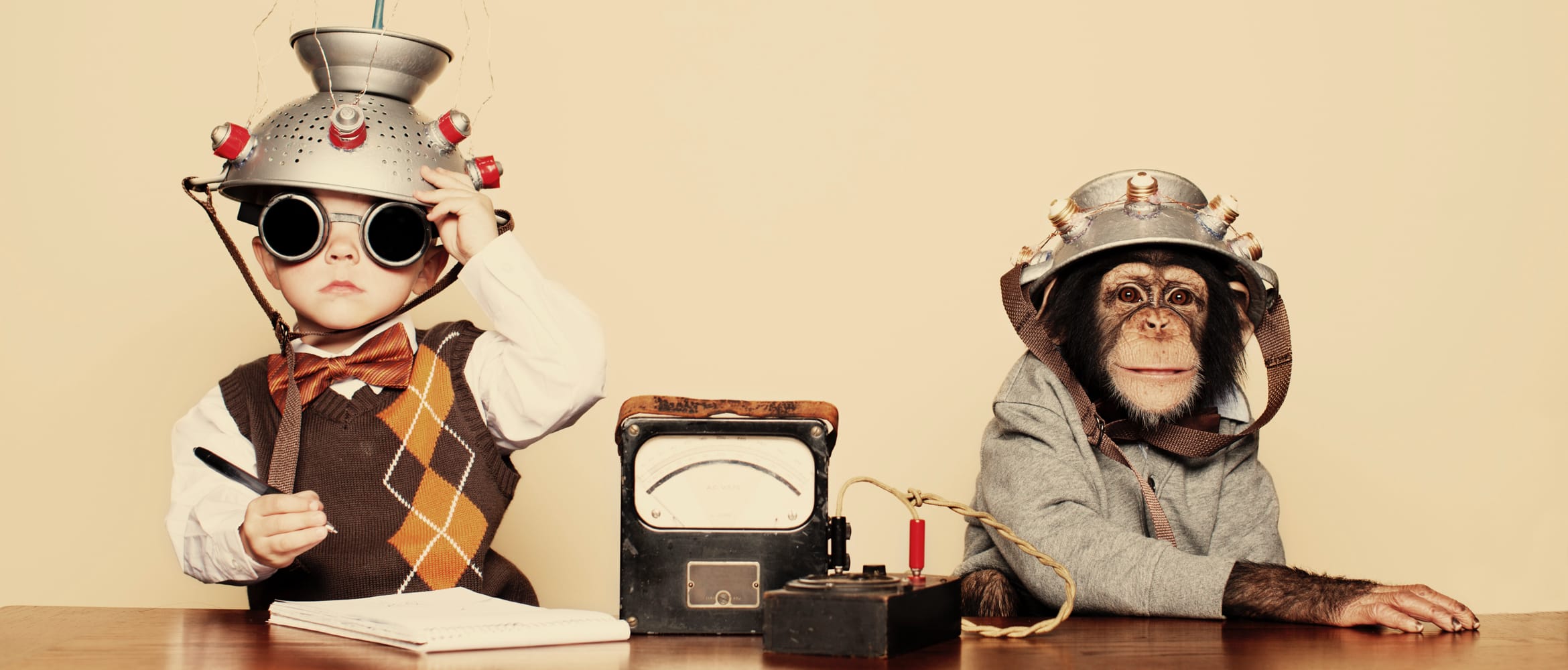 boy and a monkey sit behind a desk