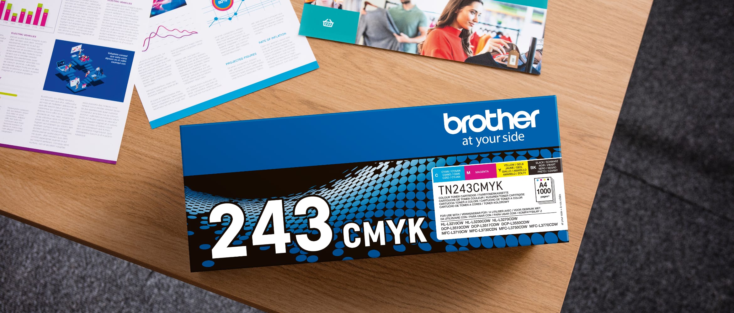 Overhead view of a Brother TN-243CMYK toner pack on a table alongside printed documents