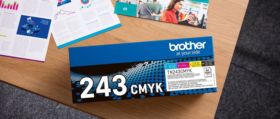 Overhead view of a Brother TN-243CMYK toner pack on a table alongside printed documents