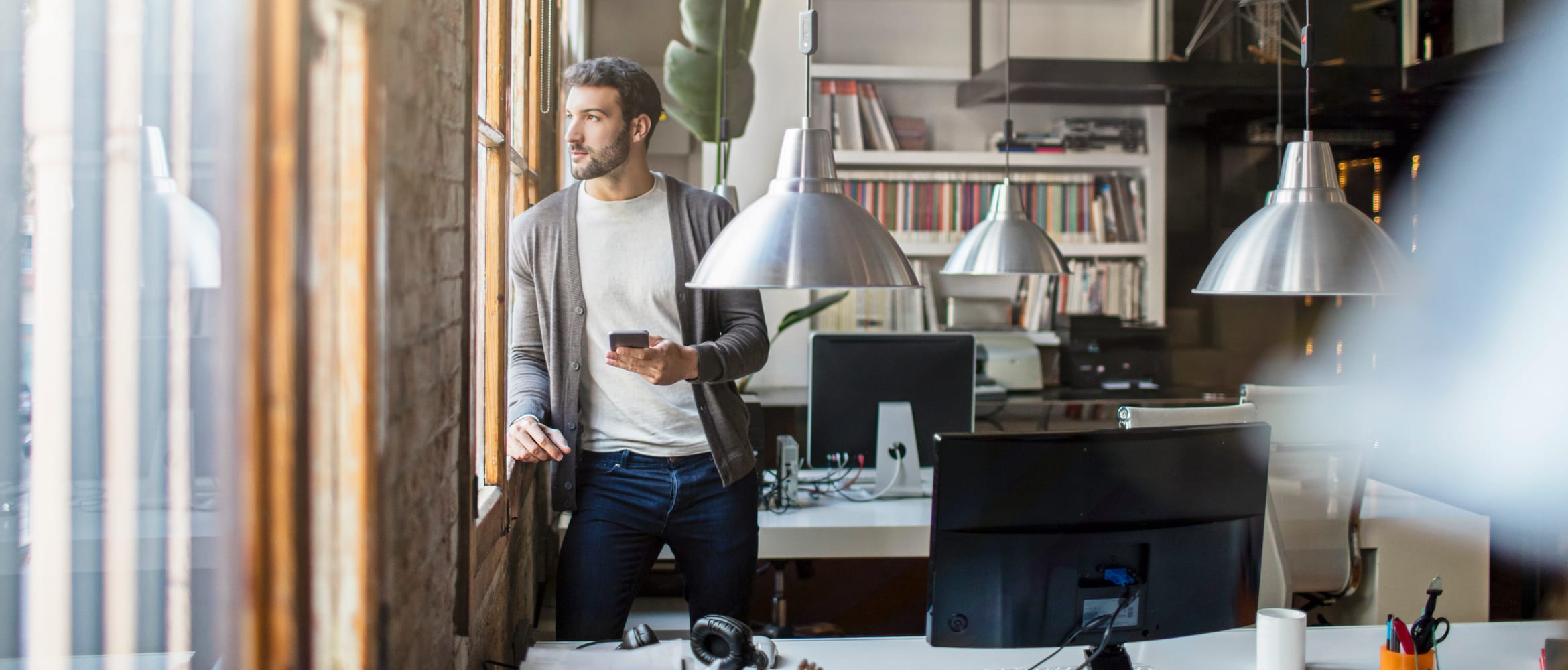 Small medium business employee uses smartphone in modern office setting