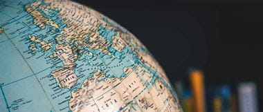 Close up on desktop globe. Europe and Northern Africa. In background out of focus books on shelves