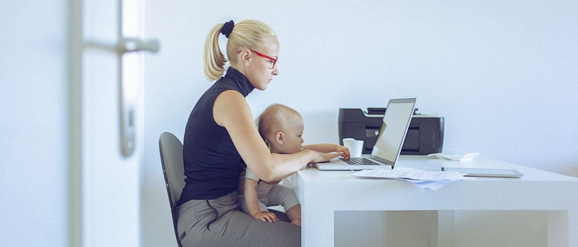 woman working from home with baby on lap