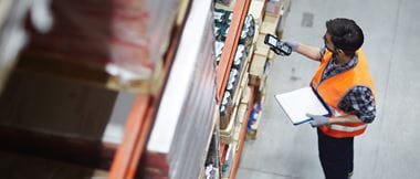 Man in a warehouse scanning with a mobile device