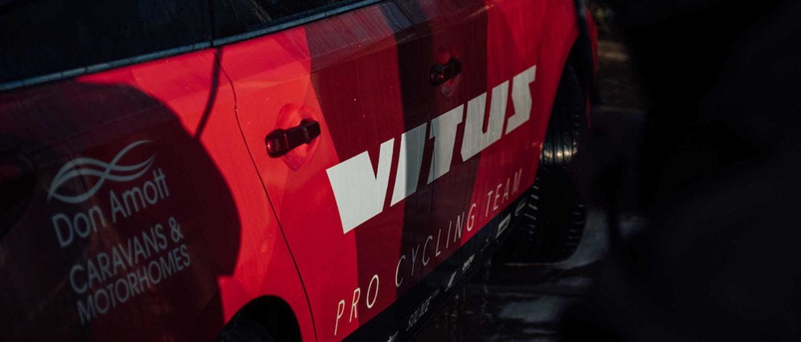Vitus logo on the side of a cycling support vehicle
