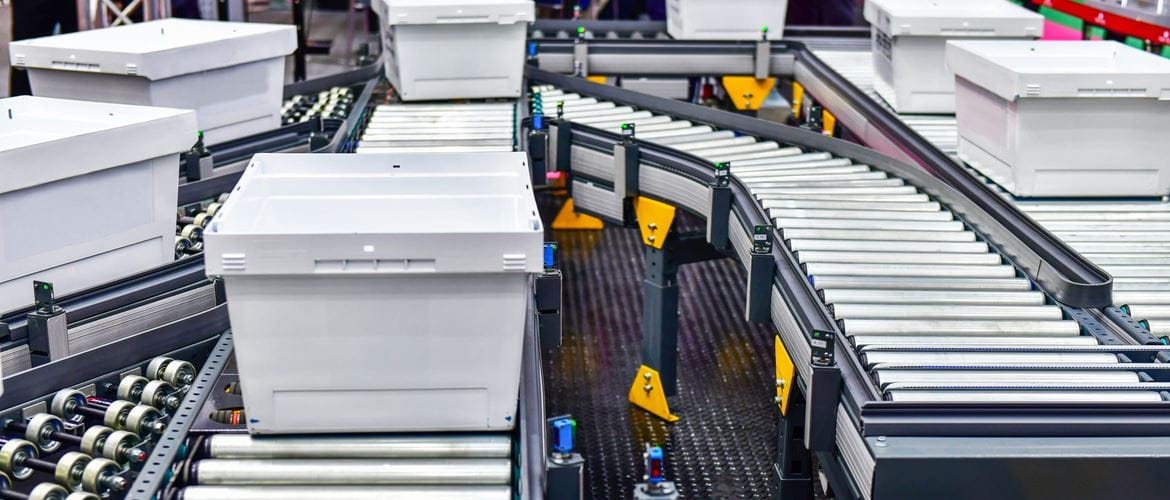 White plastic boxes on a roller conveyor in a warehouse environment