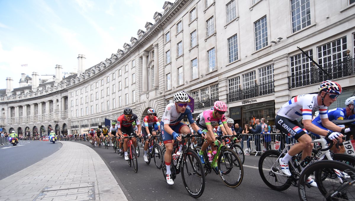 Racing cyclists, city backdrop