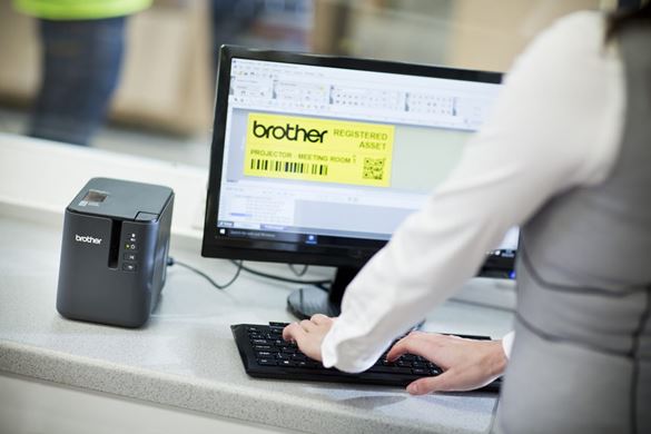 A lady using P-touch editor software to print a black on yellow QR code asset tab to a Brother label printer in a warehouse environment