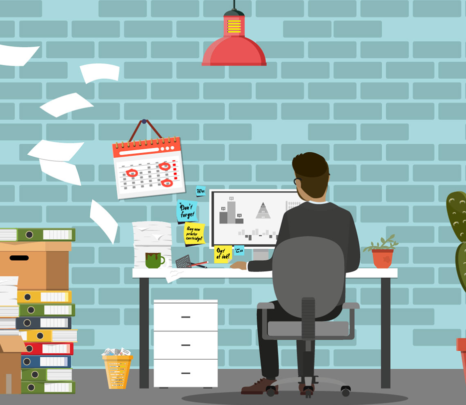 man on computer at cluttered desk