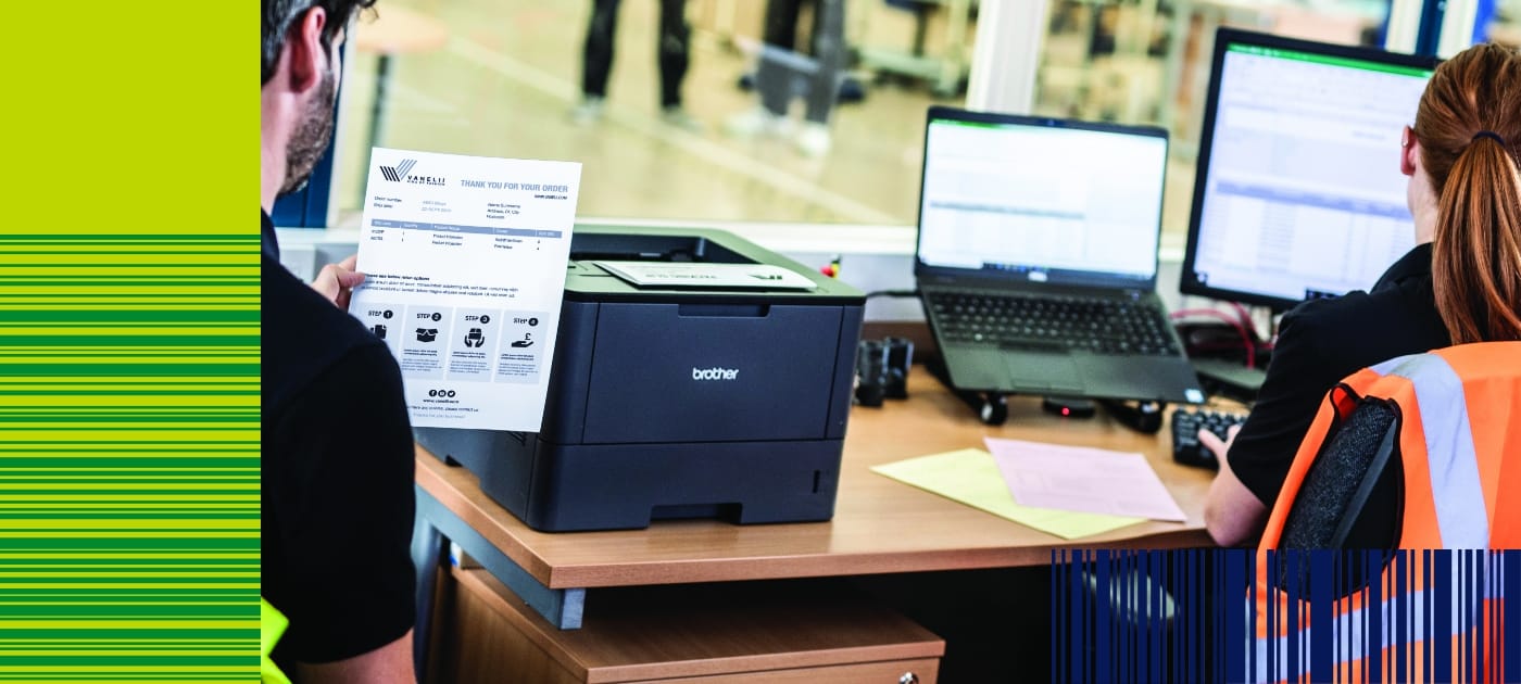 Male and female warehouse workers printing documents while sat at a desk