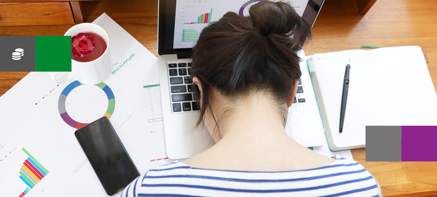 Overhead view of a business woman sat at a desk with her head facedown on the keyboard of a notebook computer