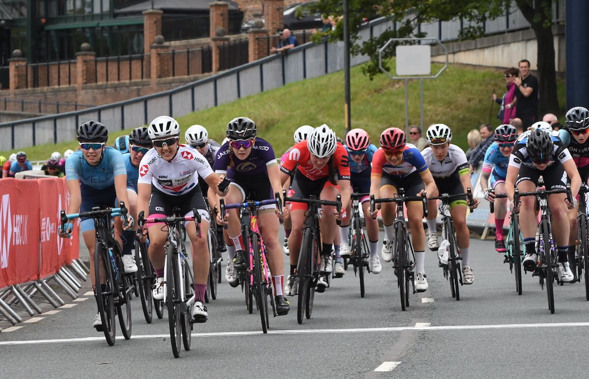 Female racing cyclists cross the finish line