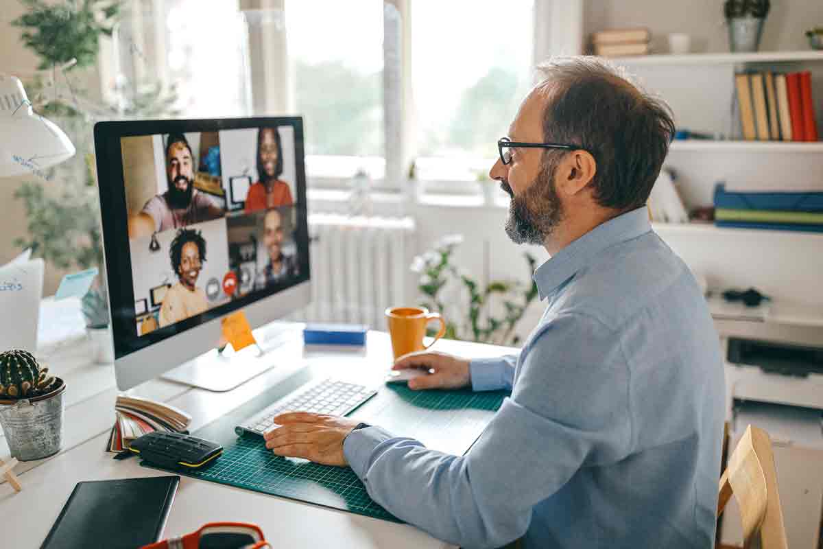 Man sat at a desk video calling colleagues