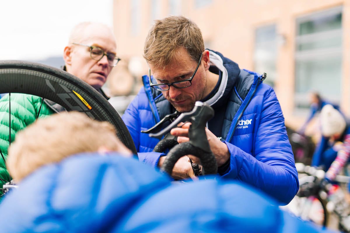 Neil Shier inspecting a brake lever with two other team members