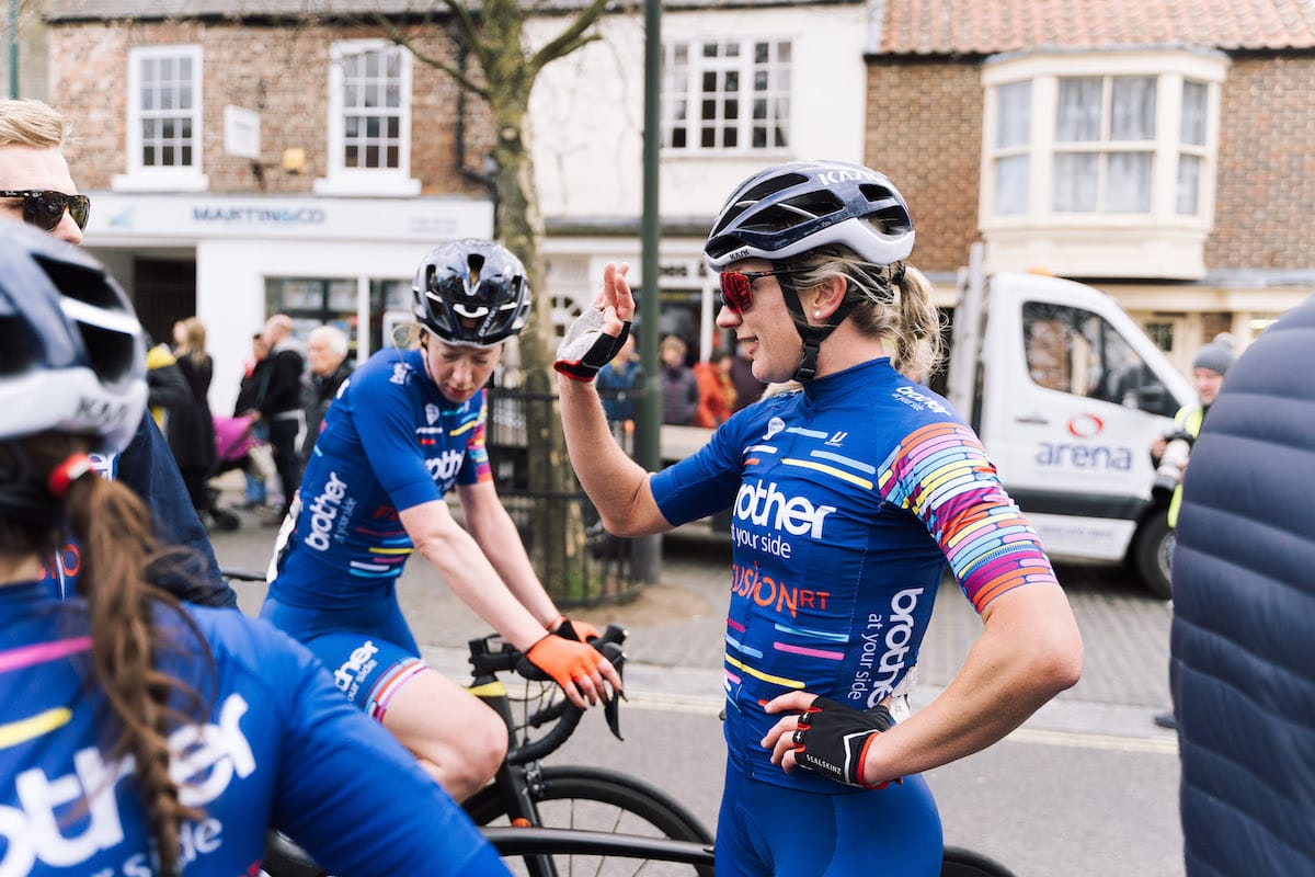 Brother UK-FusionRT team cyclists gathered together on a busy high street