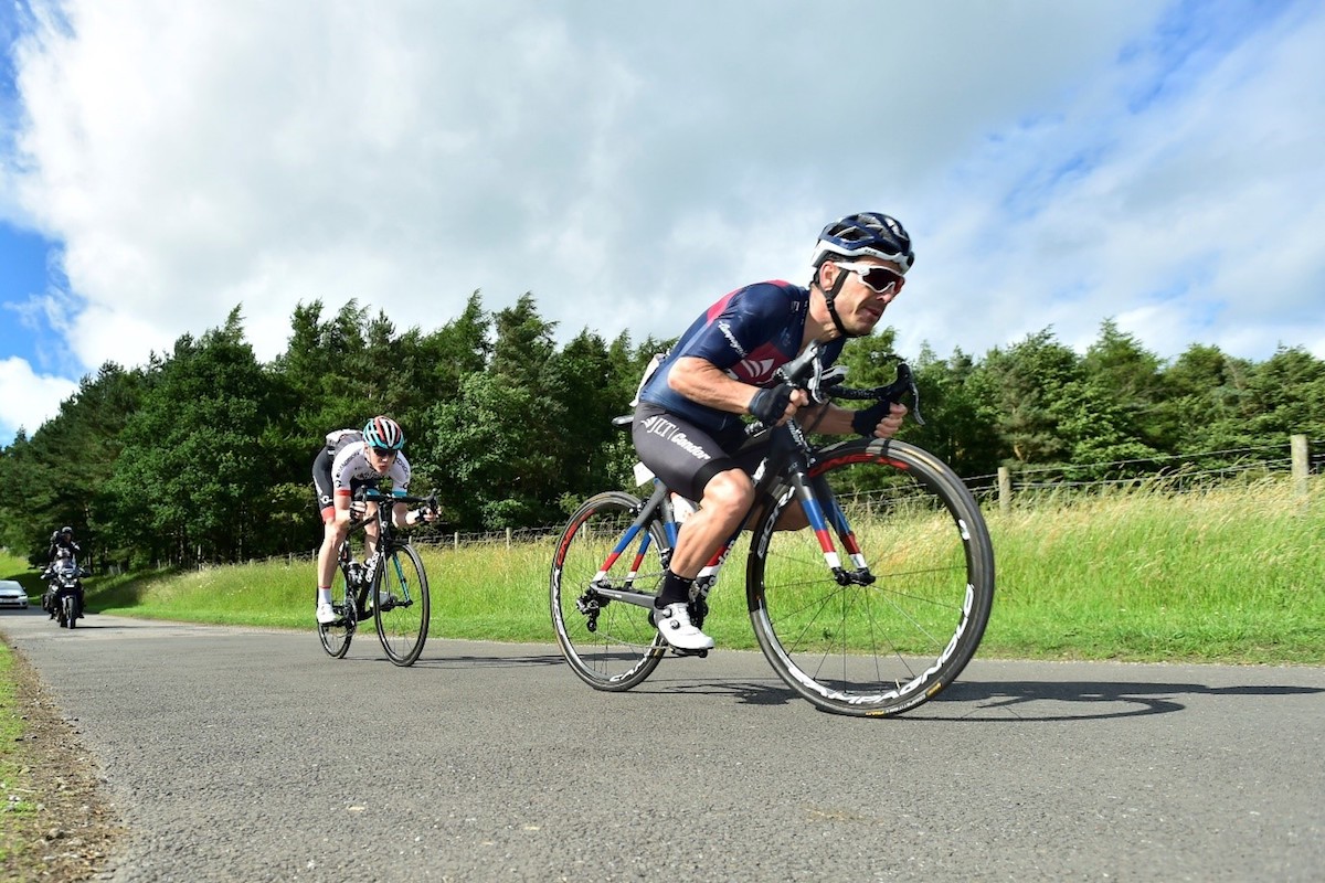 cyclist gets low to increase aerodynamics