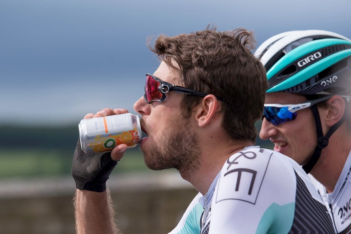 cyclist refuels with a drink