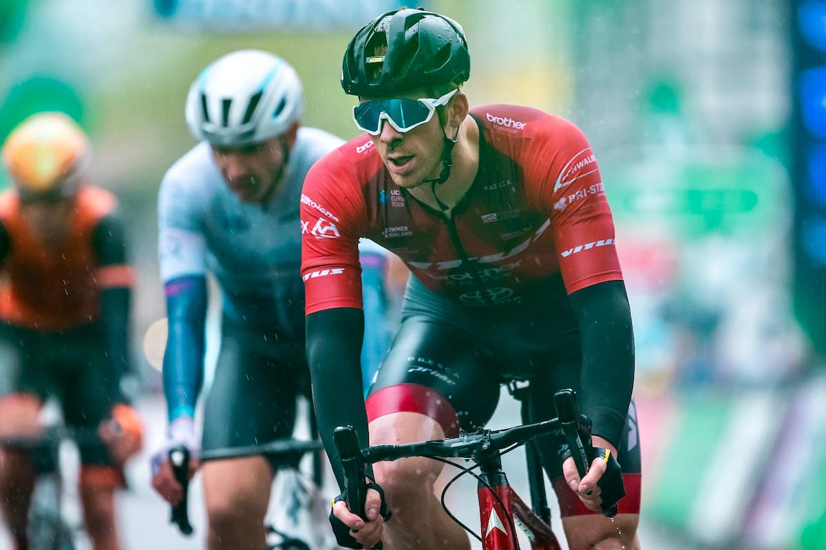 Ed Clancy riding a bike with two other cyclists in the background