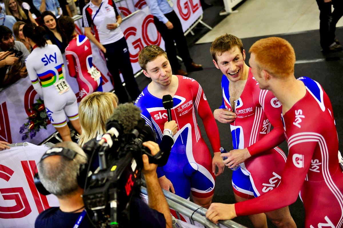 Cyclist Ed Clancy being interviewed alongside two team mates at an indoor event
