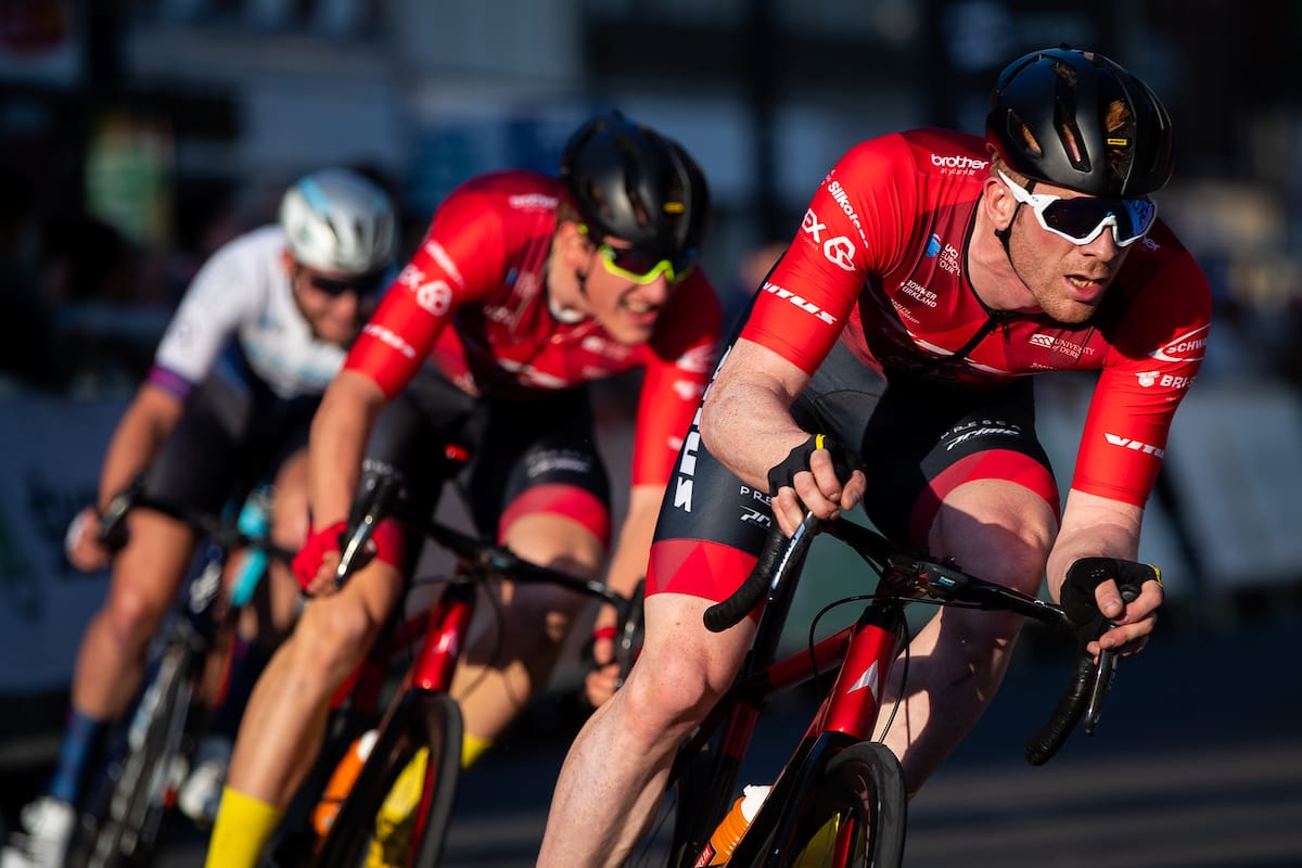 Ed Clancy leaning into a corner with two other cyclists following