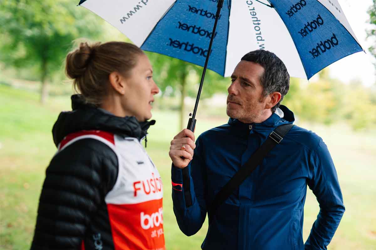 Fusion RT cyclists chatting under an umbrella to Brother UK's Managing Director, Phil Jones