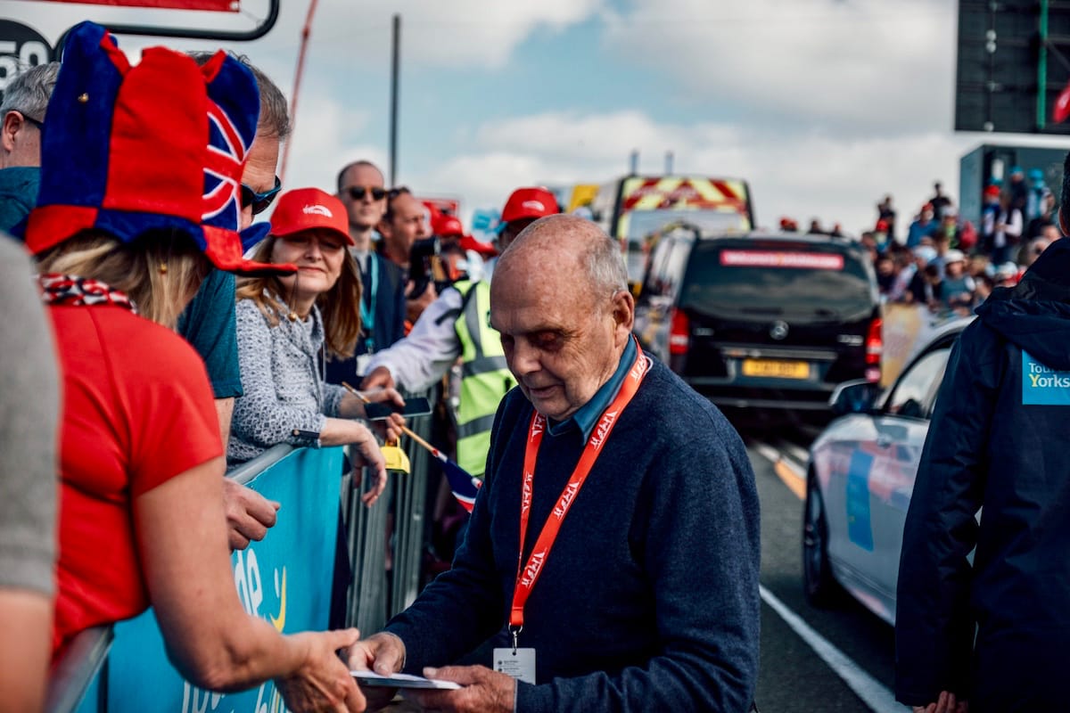 Jake Womersley's grandfather, Brian Robinson, handing out information to spectators at a race