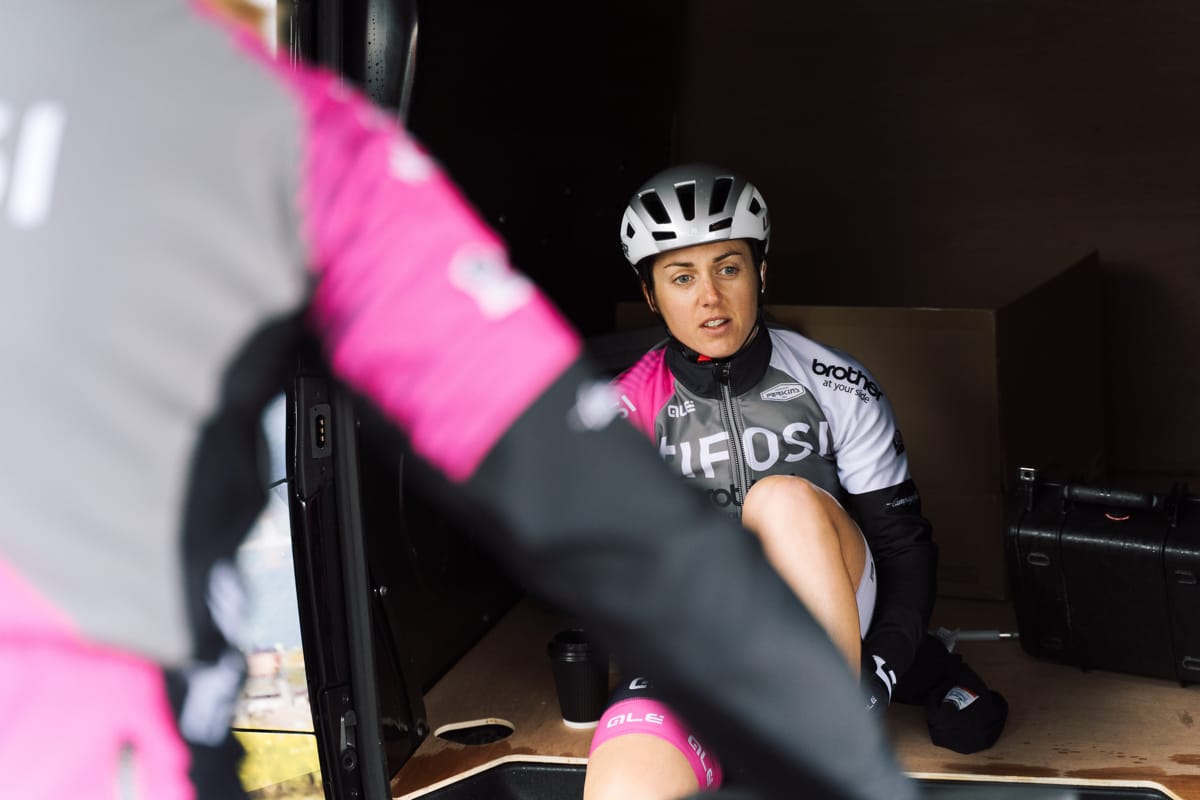 Cyclist Rebecca Durrell sitting on the side door sill of a support vehicle