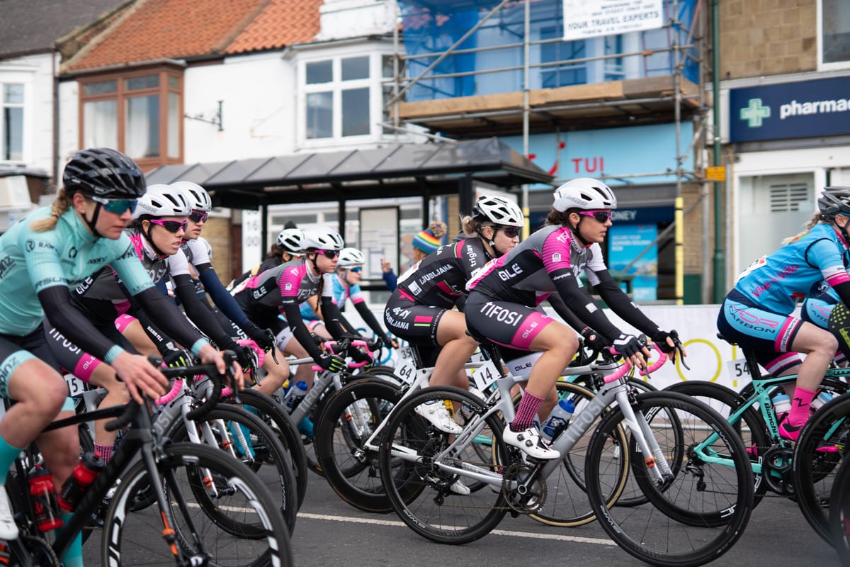 Rebecca Durrell amongst a group of cyclists while racing along a high street