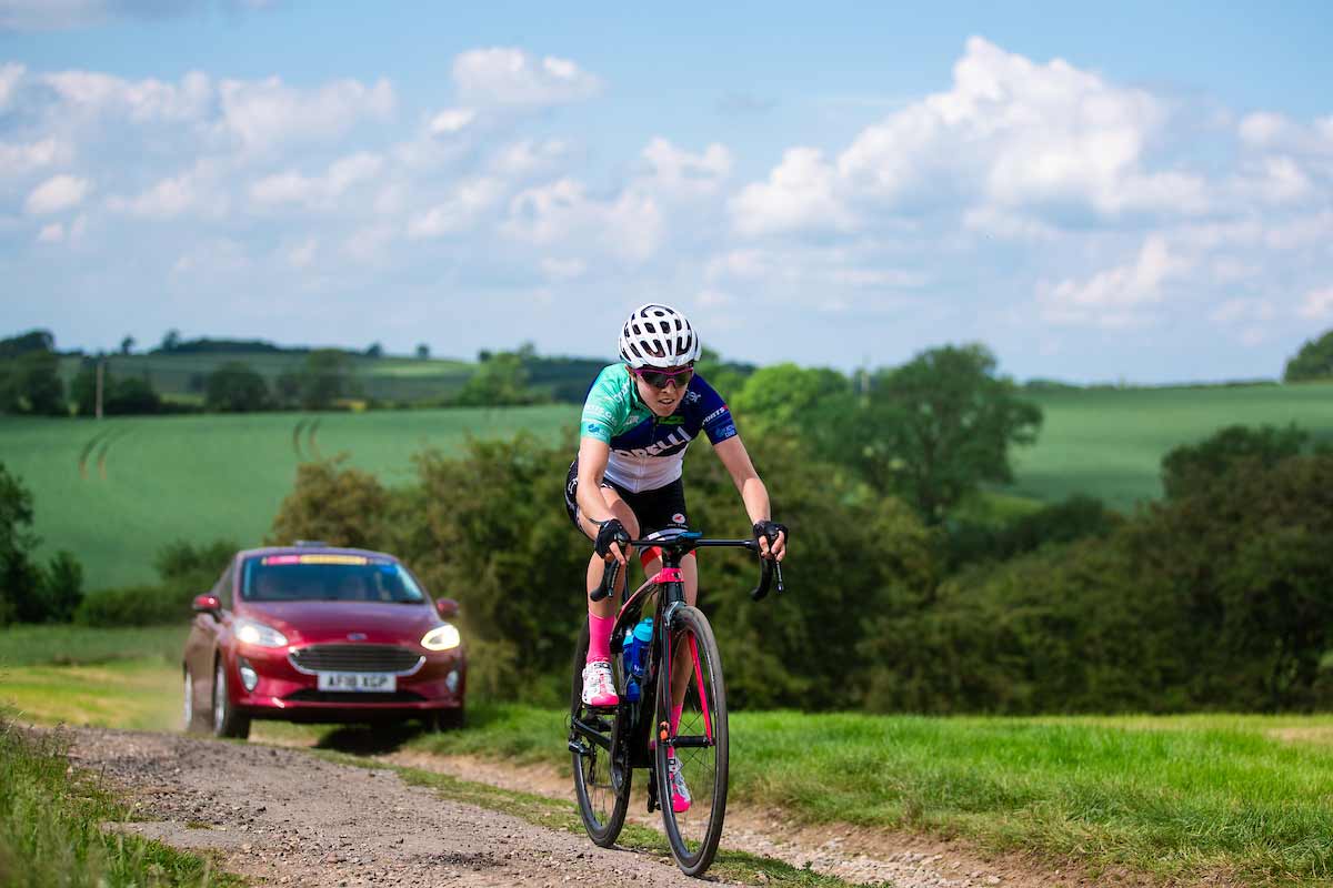 Cyclist Sophie Wright followed by a support car
